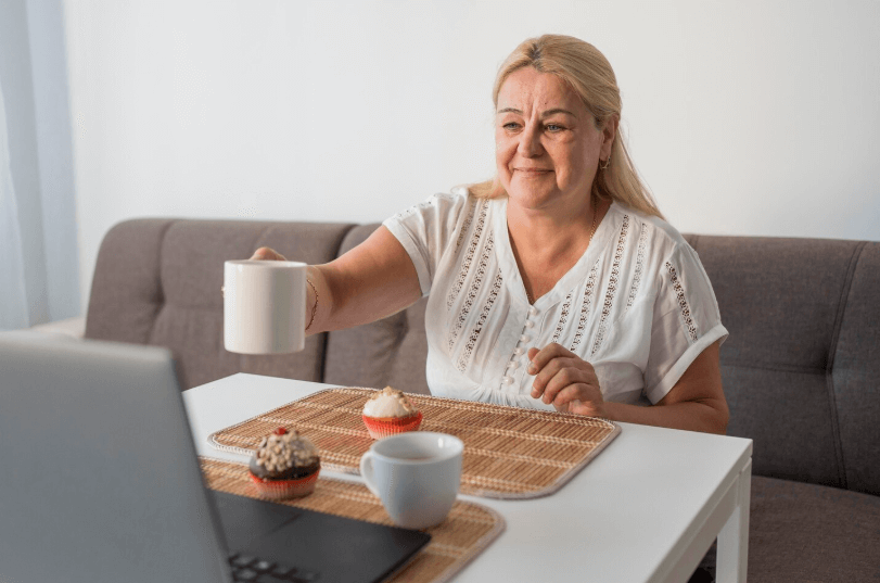 older woman sitting at the table eith cup of coffe